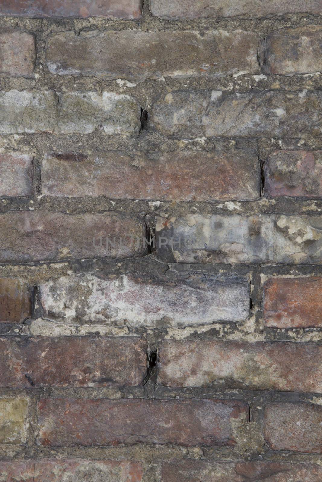 background or texture of a old wheathered an repaired brick wall