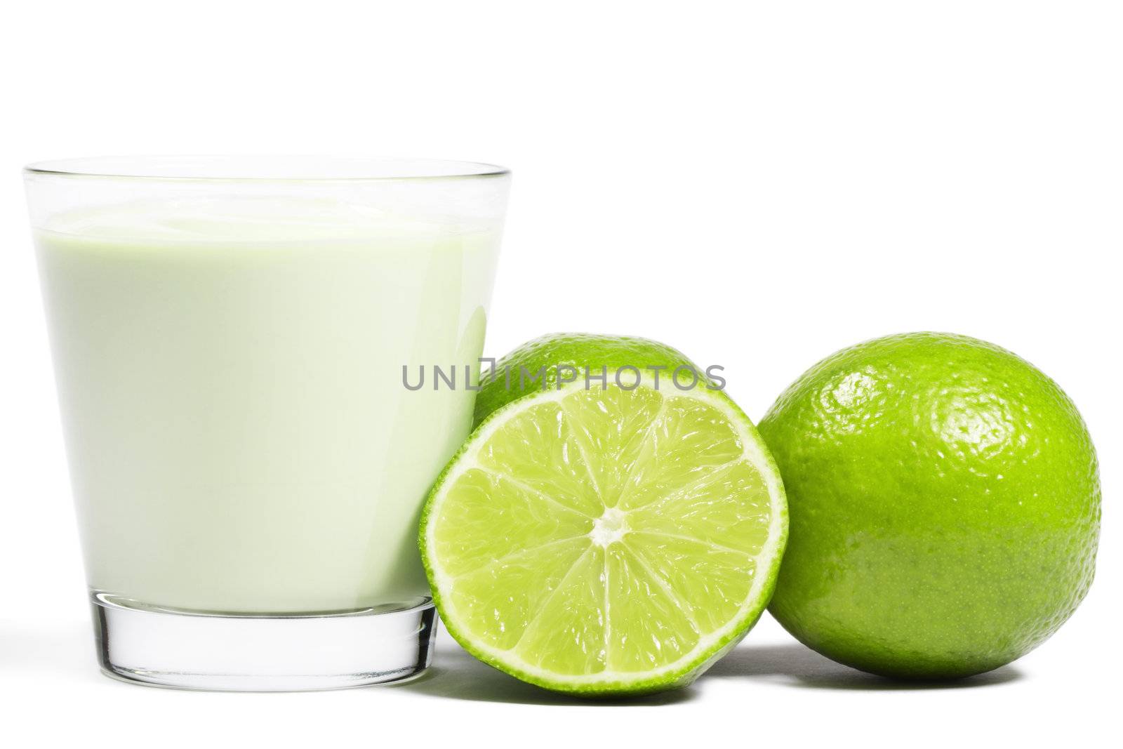 limes and a half near milkshake on white background