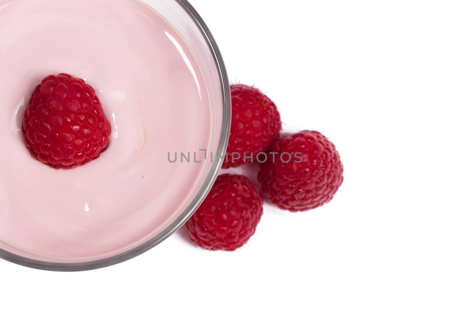 raspberry on top of a milkshake with rapsberries aside from top on white background