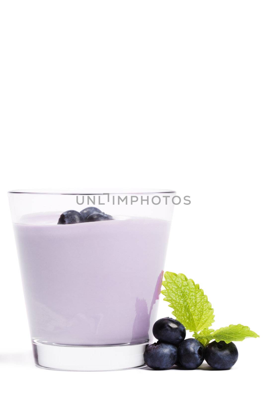 some blueberries with melissa near a milkshake with blueberries on white background