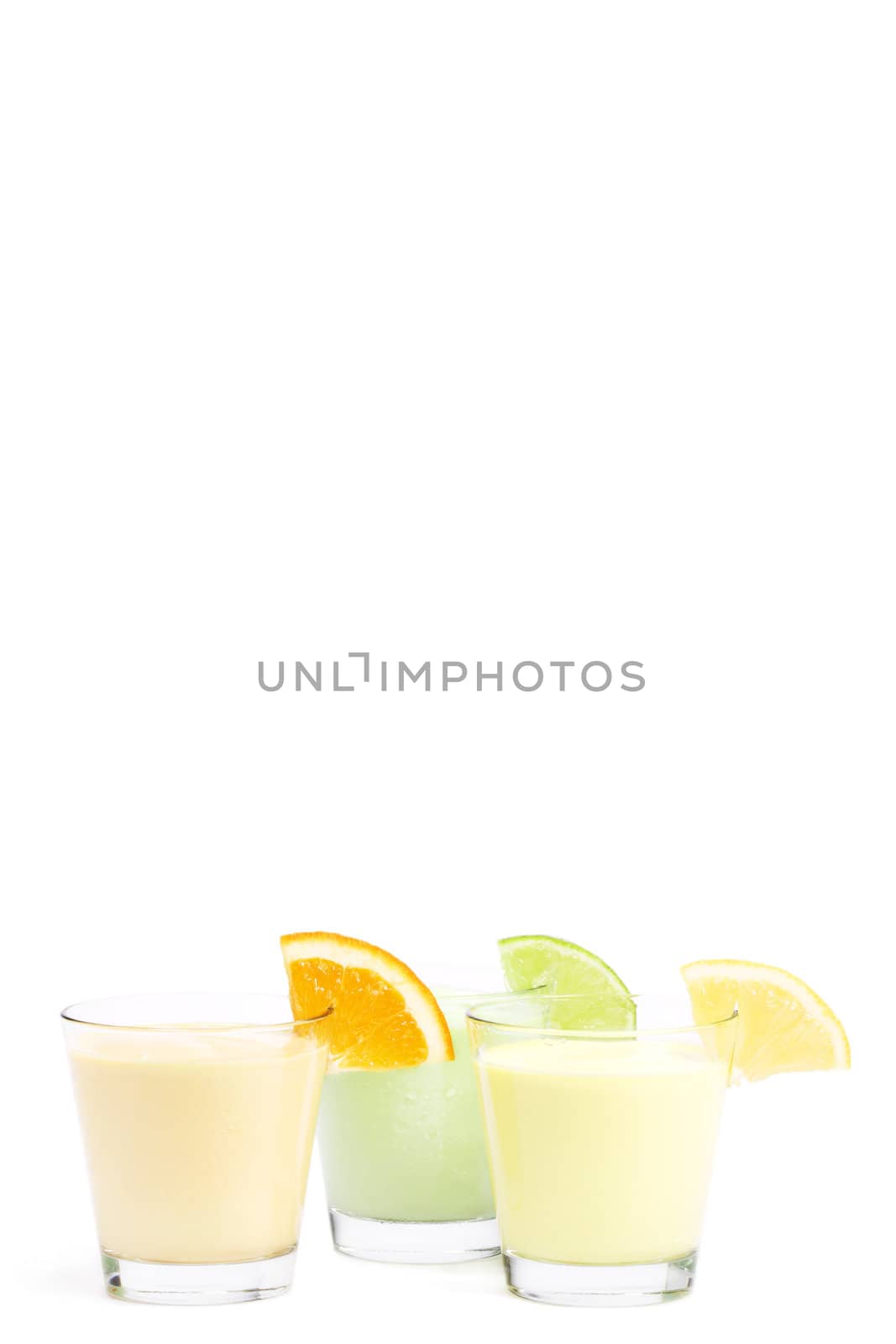 three cold citrus fruit milkshakes on white background