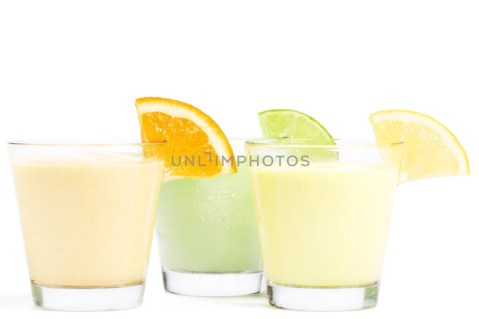 three cold citrus fruit milkshakes on white background