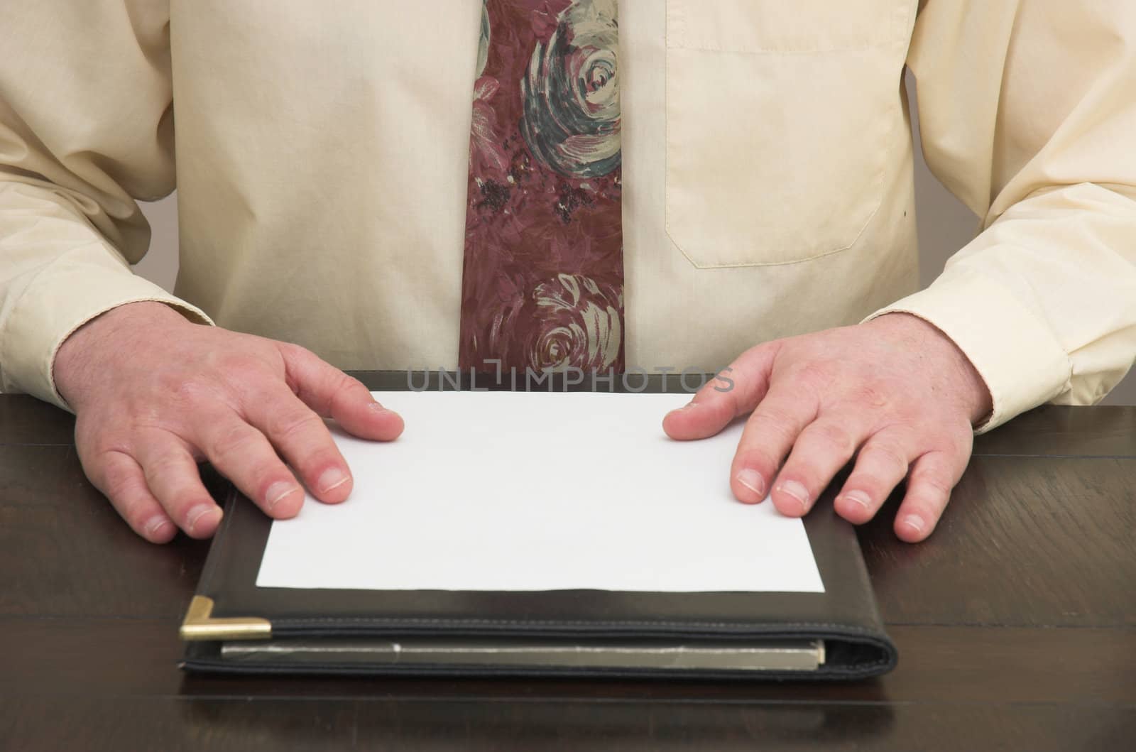 Man working at desk faced with blank sheet of paper.
