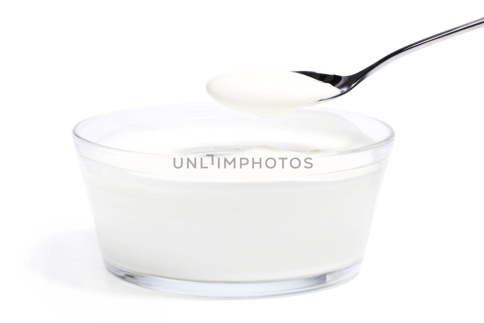 yogurt on a spoon over yogurt in a glass bowl by RobStark