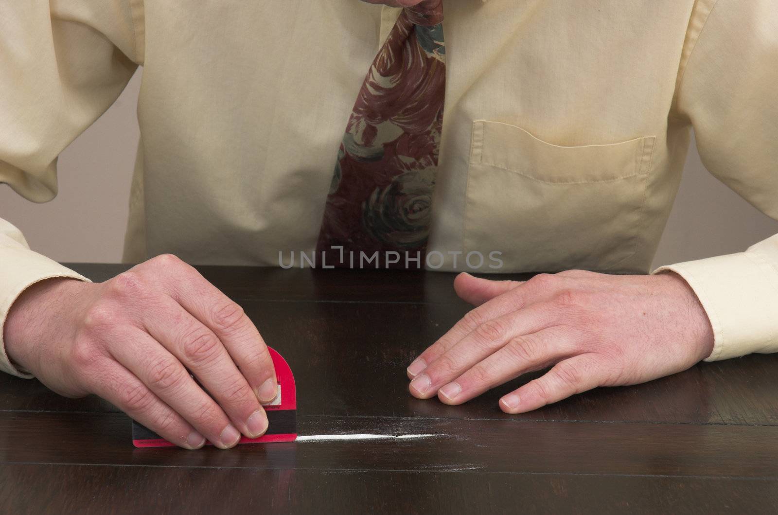 Man preparing a line of cocaine with a credit card.