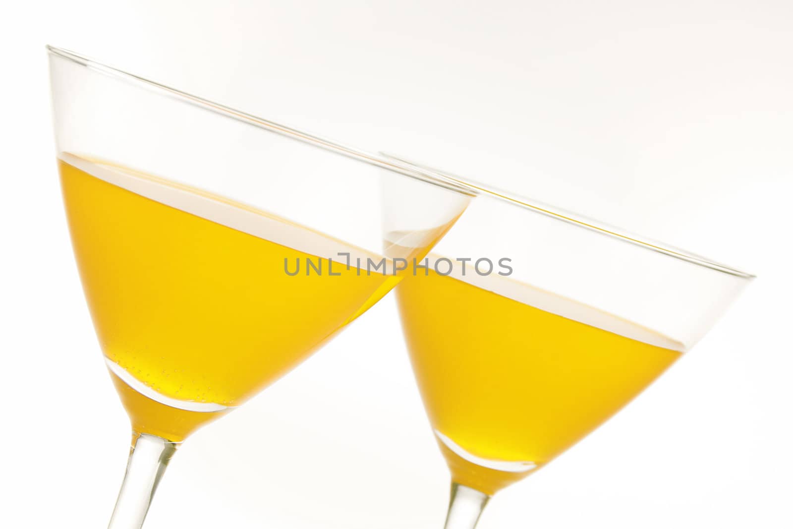 Close-up of two cocktail glasses with yellow liquid inside and lot of copy space