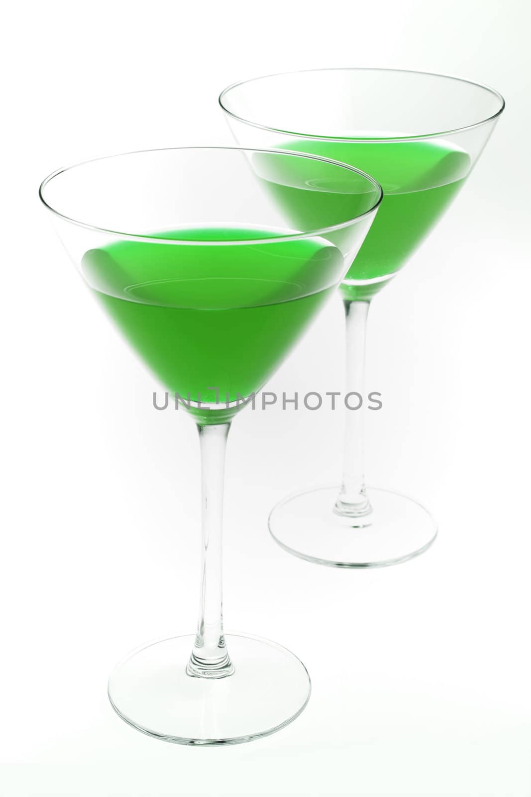Two cocktail glasses with green liquid inside, isolated on white