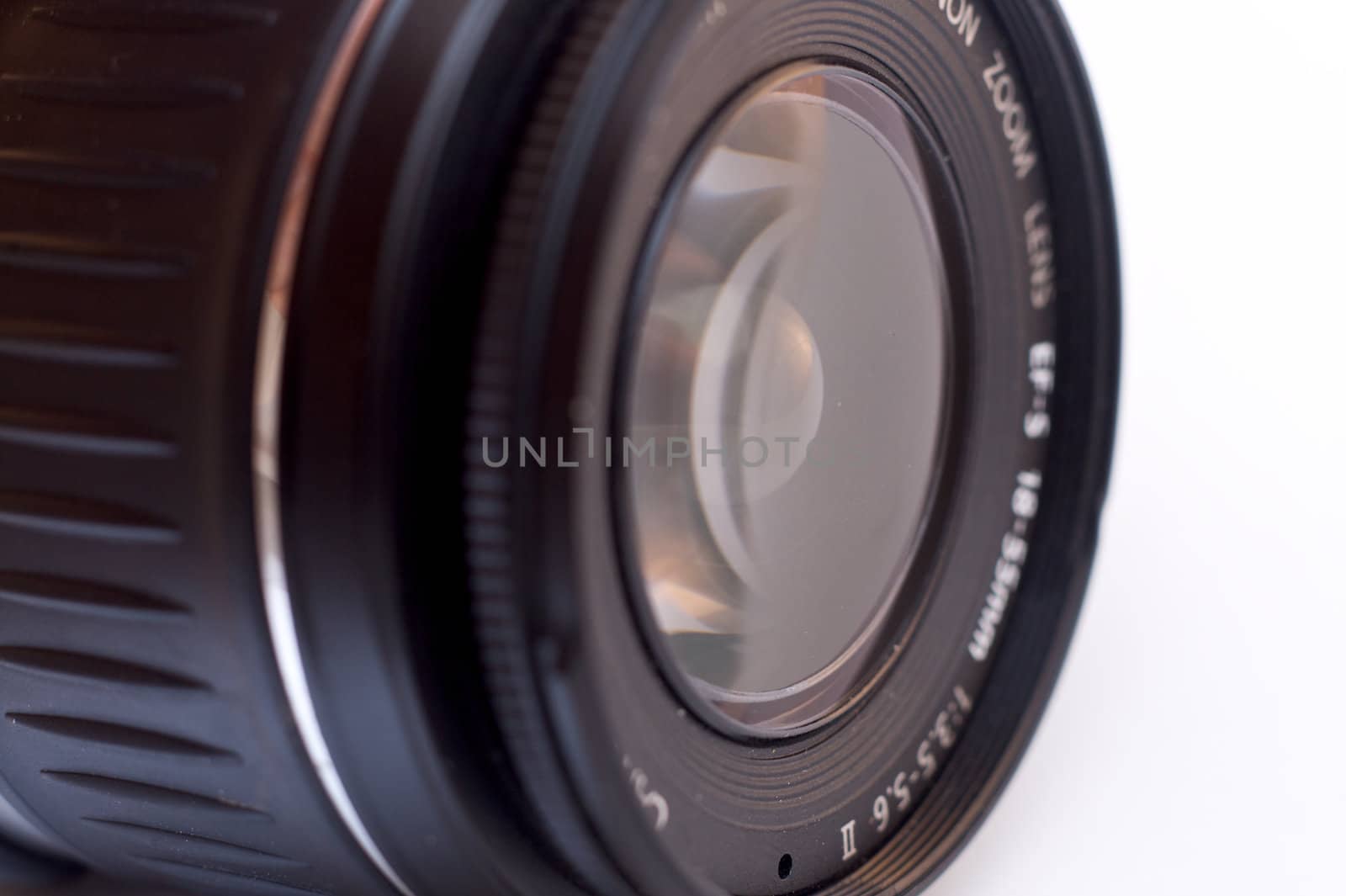 A photographic lens seen from a side angle over white