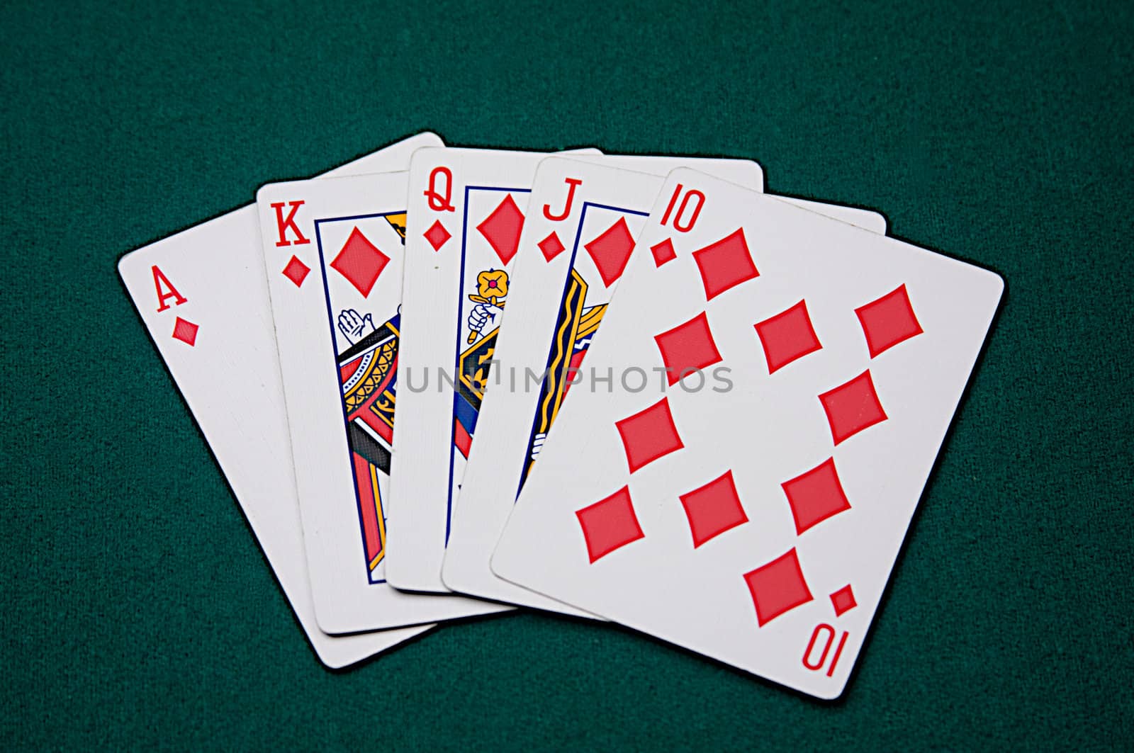 The highest possible hand in poker, a royal flush, seen on green felt