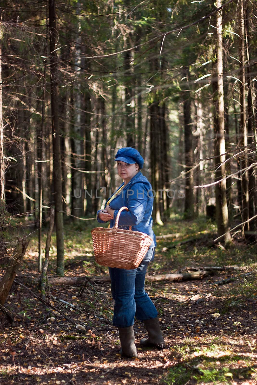 Woman in the forest with wooden basket in hands