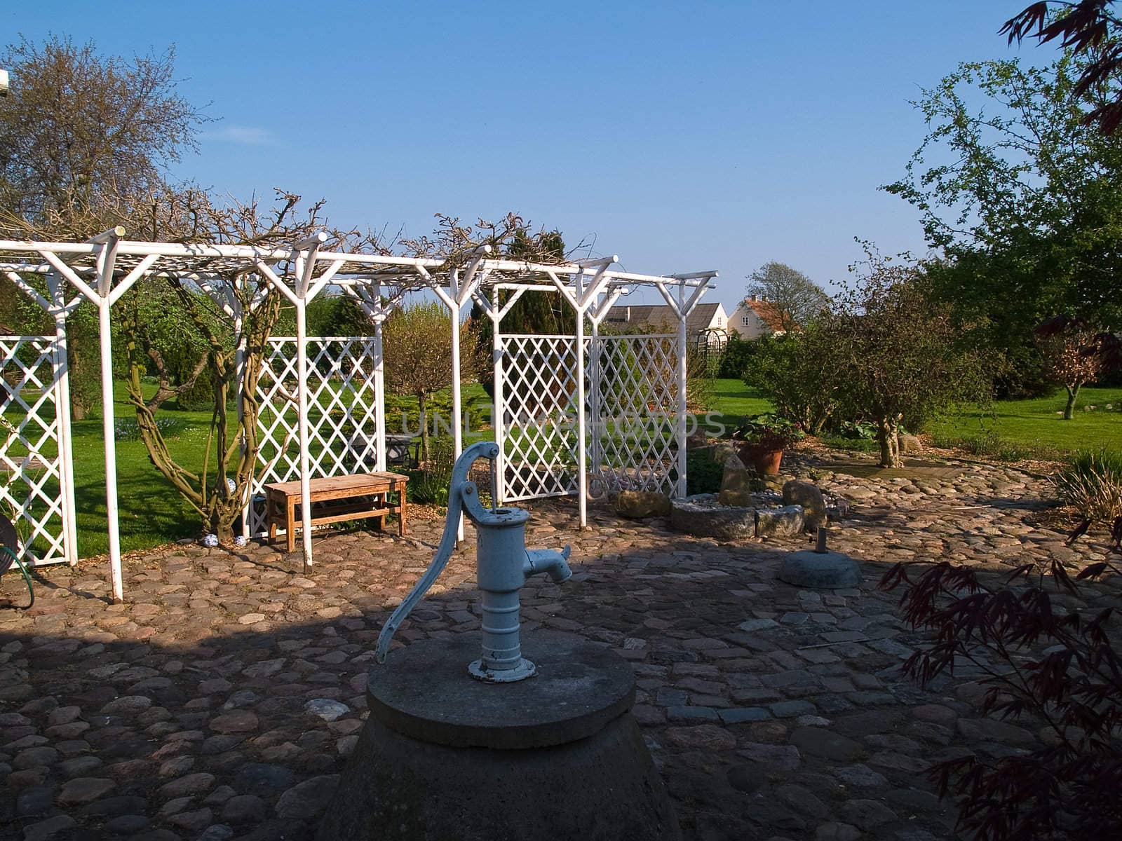 Beautiful small wooden garden pergola gazebo arbor with old water pump