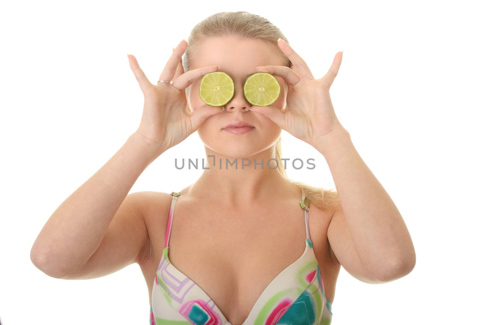 Young woman holding a slices of lime in front of her eyes isolated on white background