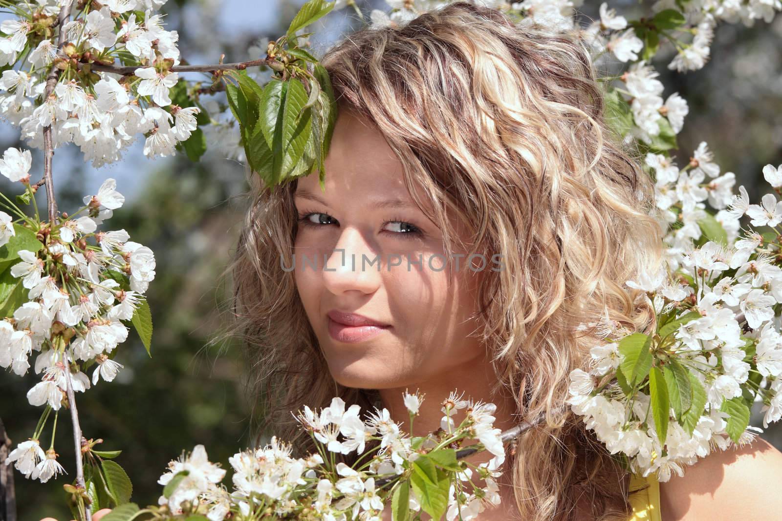 Beautiful blond woman between tree with white flowers by BDS