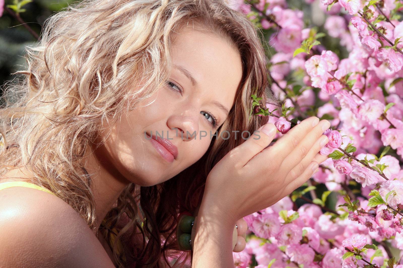 Beautiful blond woman between pink flowers by BDS