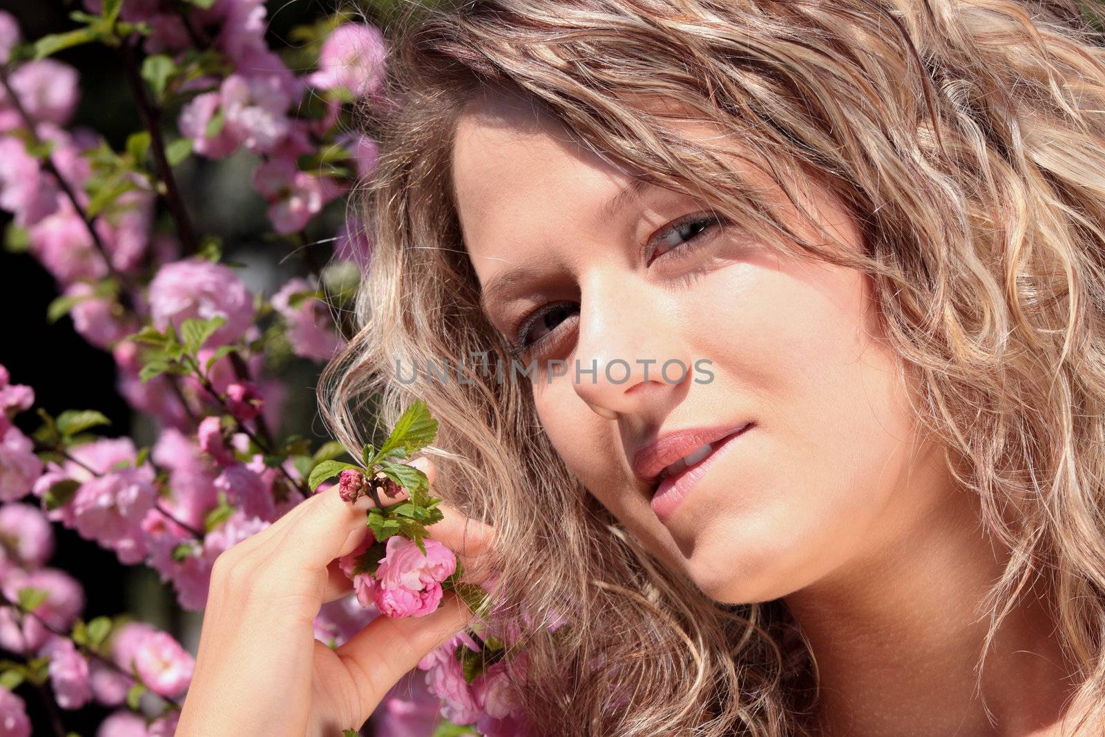 Beautiful blond woman between pink flowers by BDS