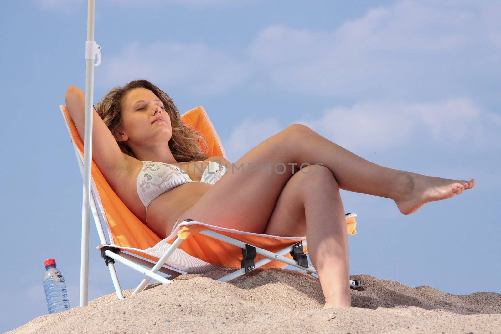 Woman relaxing on the beach by BDS