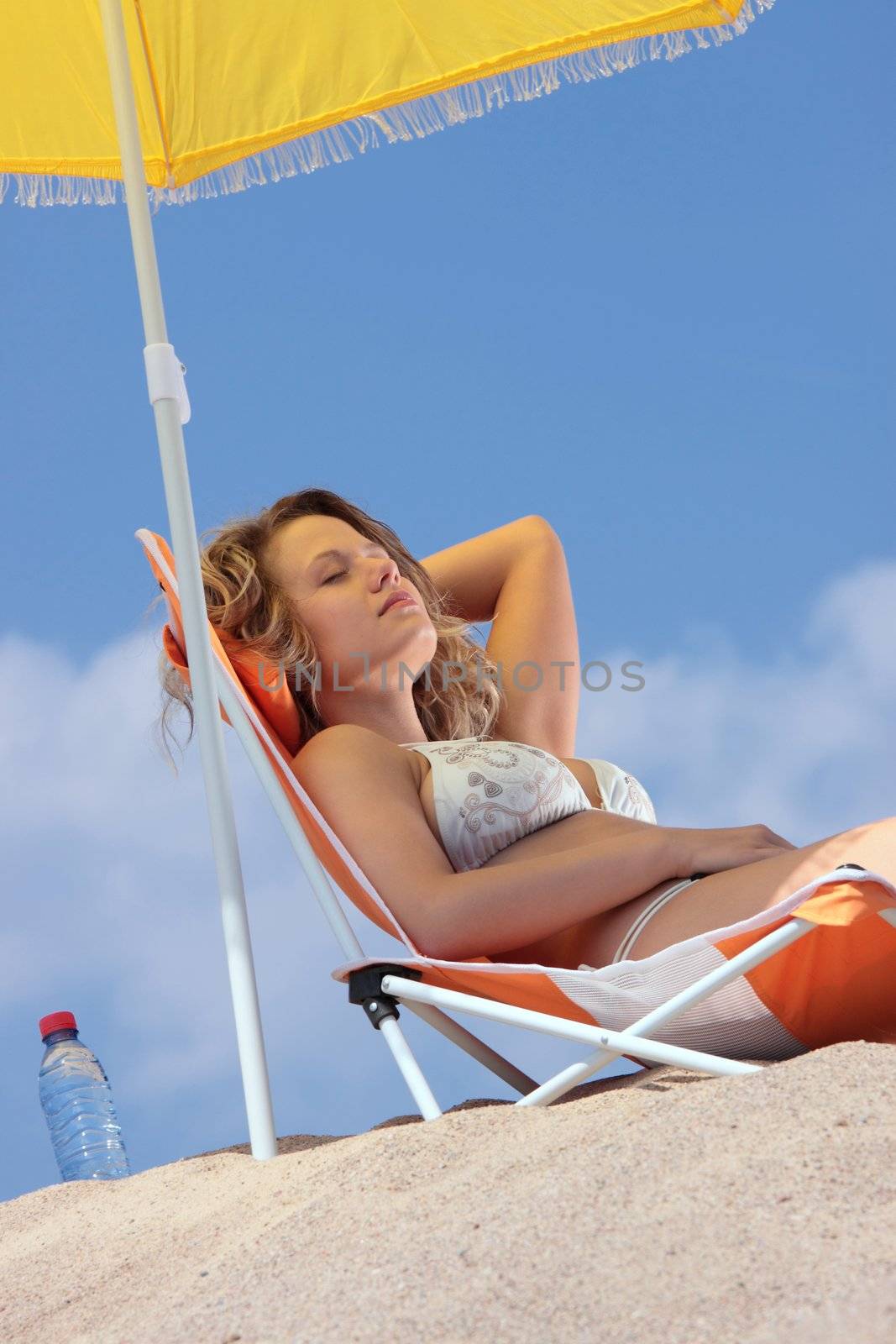 Woman relaxing on the beach by BDS