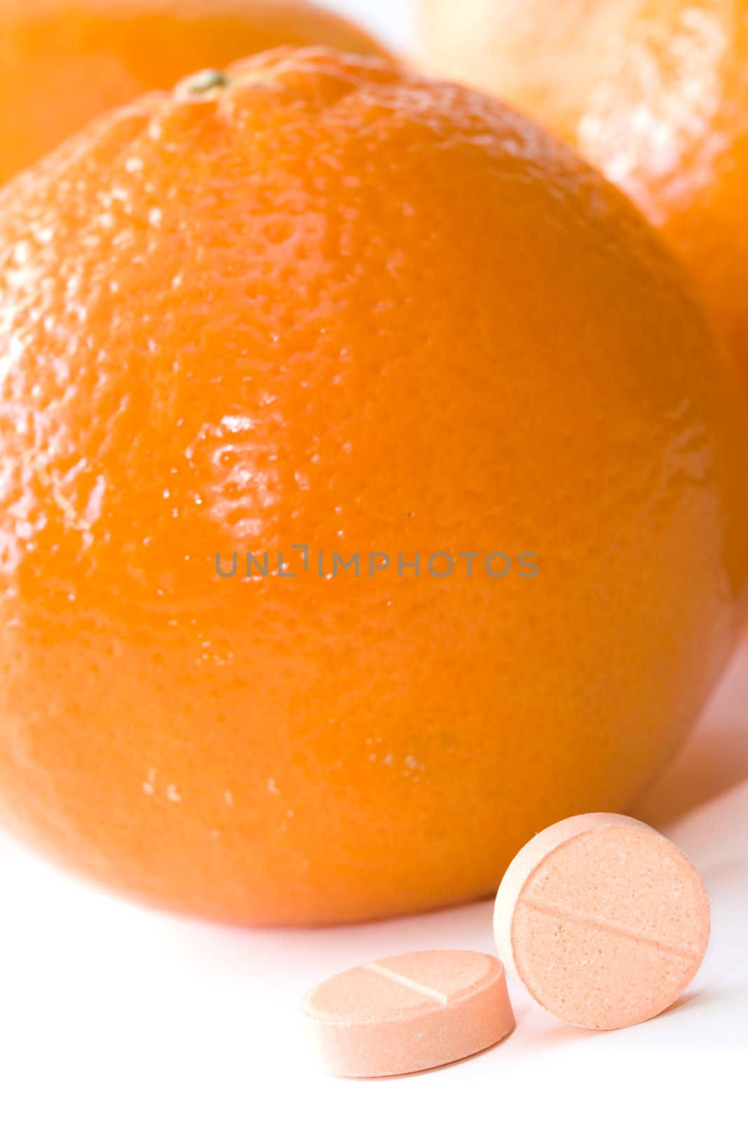 Pills of vitamin C on a background of orange