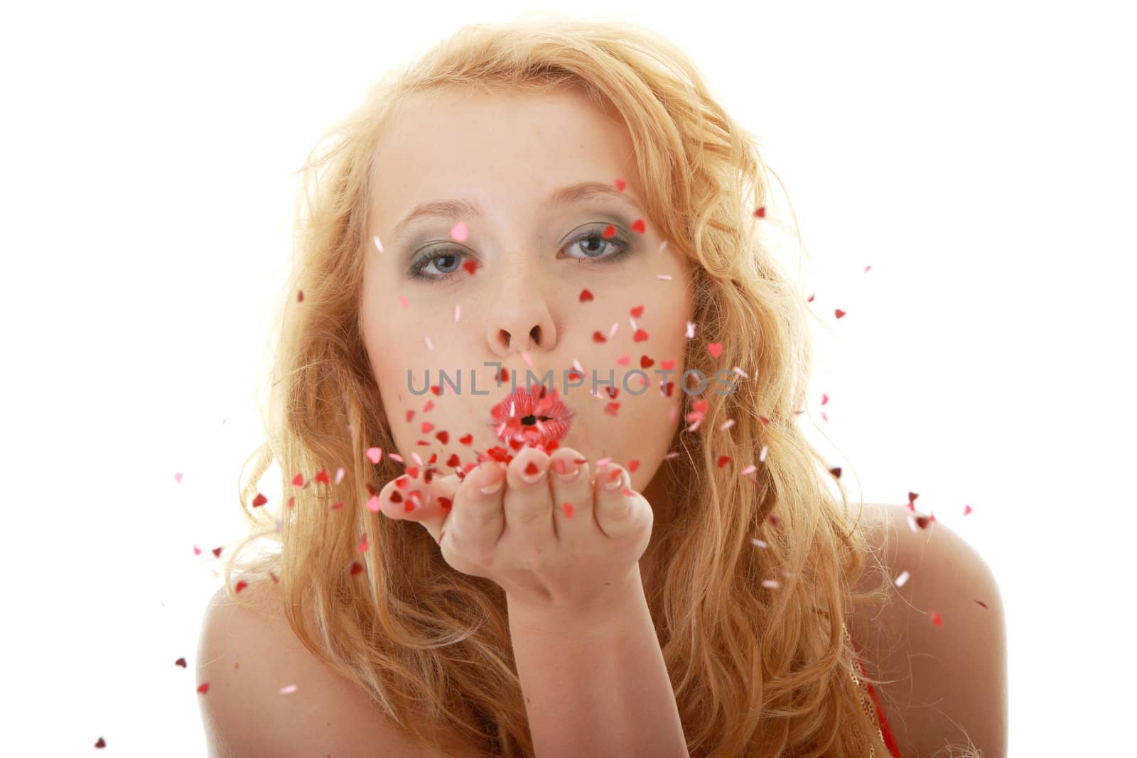 Pretty young woman blowing a kiss with a swirl of hearts on white background