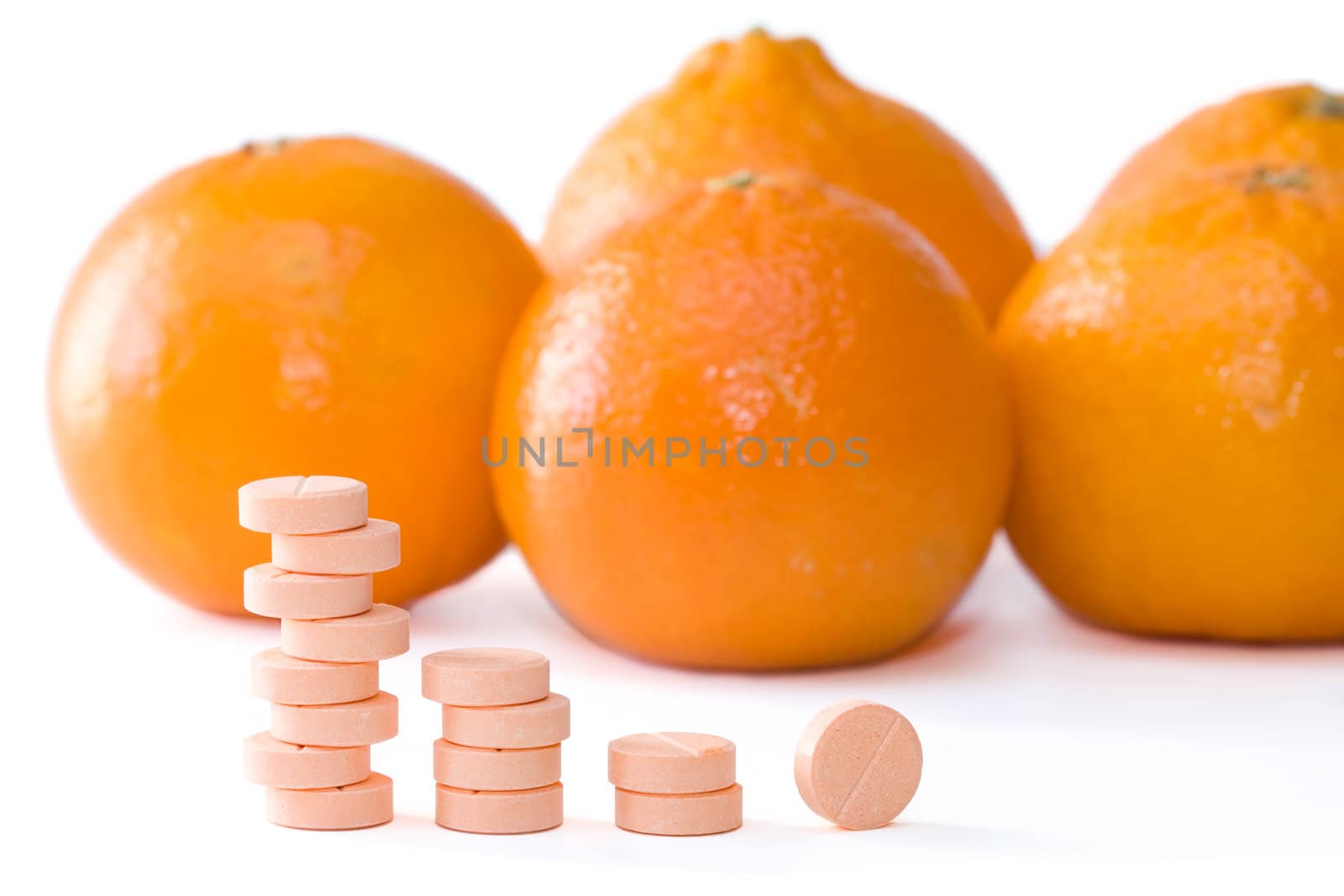 Pills of vitamin C on a background of orange