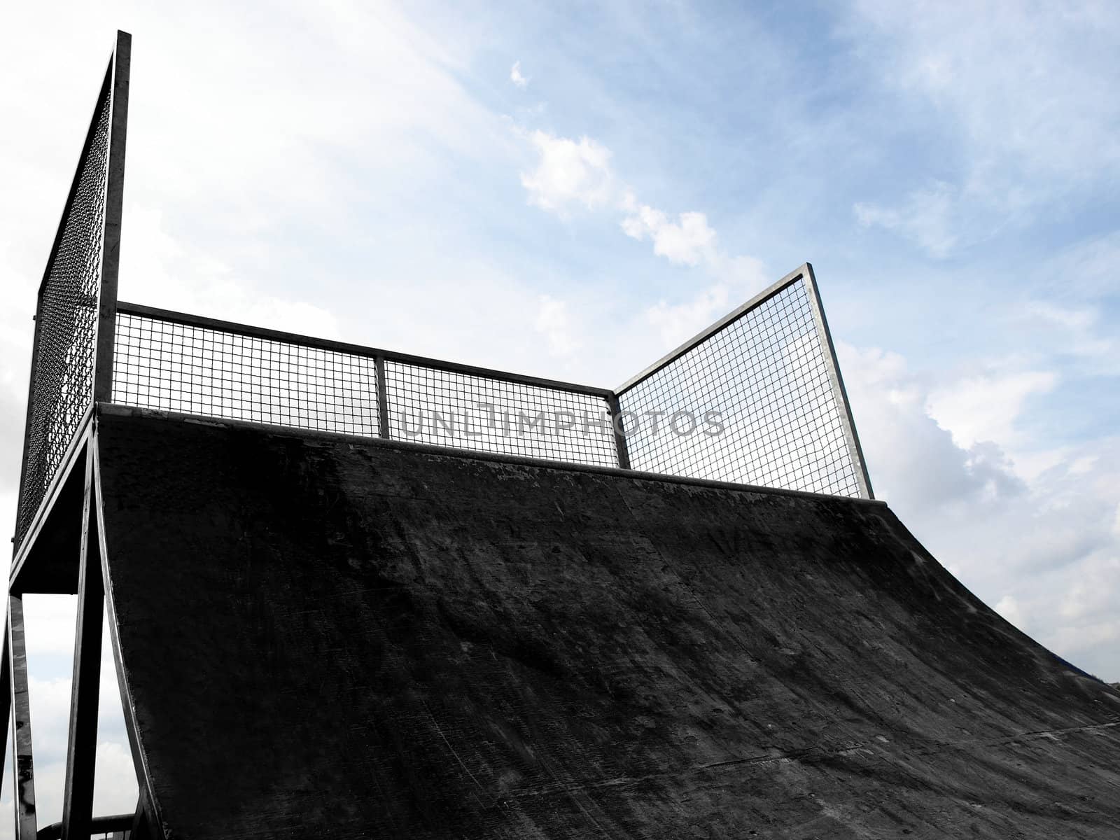 Grunge skate ramp seen from skater's point of view, over blue sky - with copy space