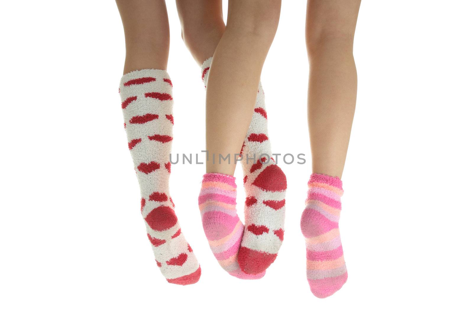 Four crossed legs with colorful socks (isolated on white) - friendship or love concept