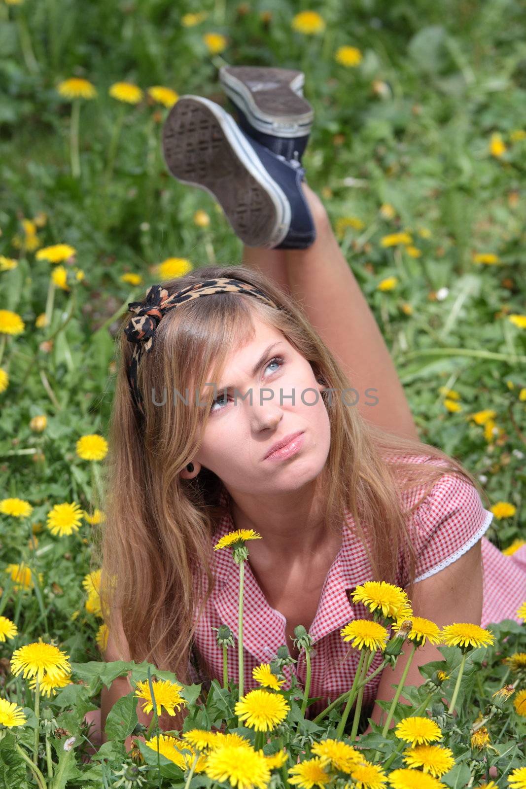 Beautiful woman relaxing in the grass and flowers by BDS