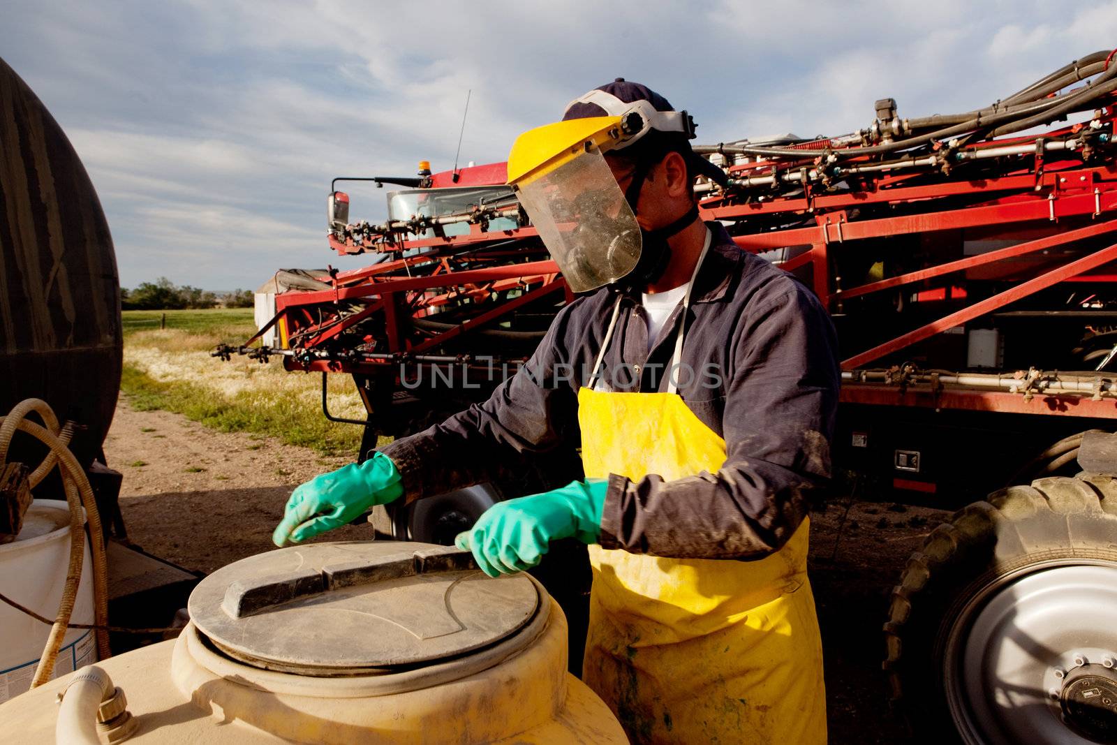 Filling a high clearance sprayer with chemical and water with proper safety equipment