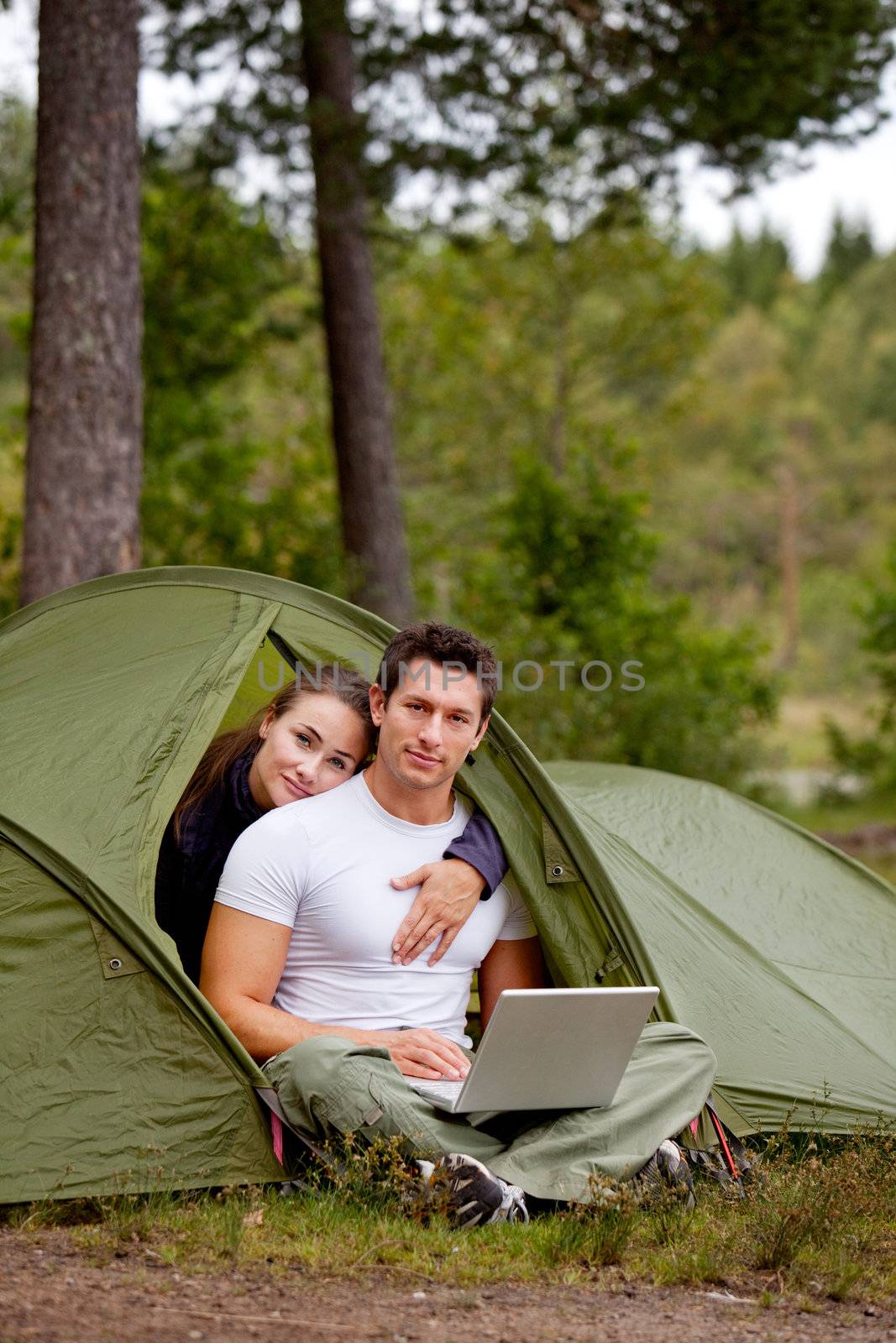 A couple using a computer while camping