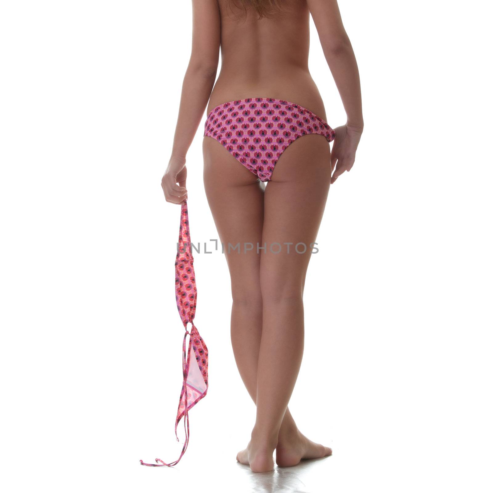 Young woman topless - with top of bikini in her hand,her back towards to camera, isolated on white background (tourism concept)