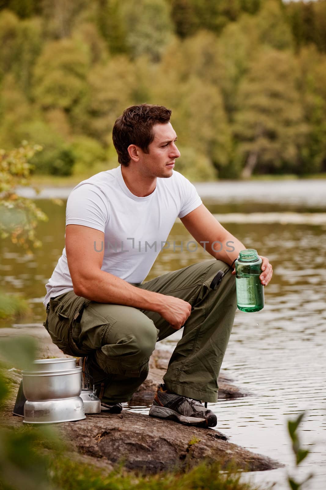 A man getting water on a camping trip in the forest