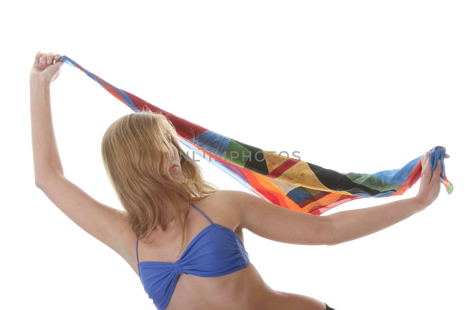 A beautiful young blond woman wearing a blue bikini with colorfull material blowing in the wind isolated on white background