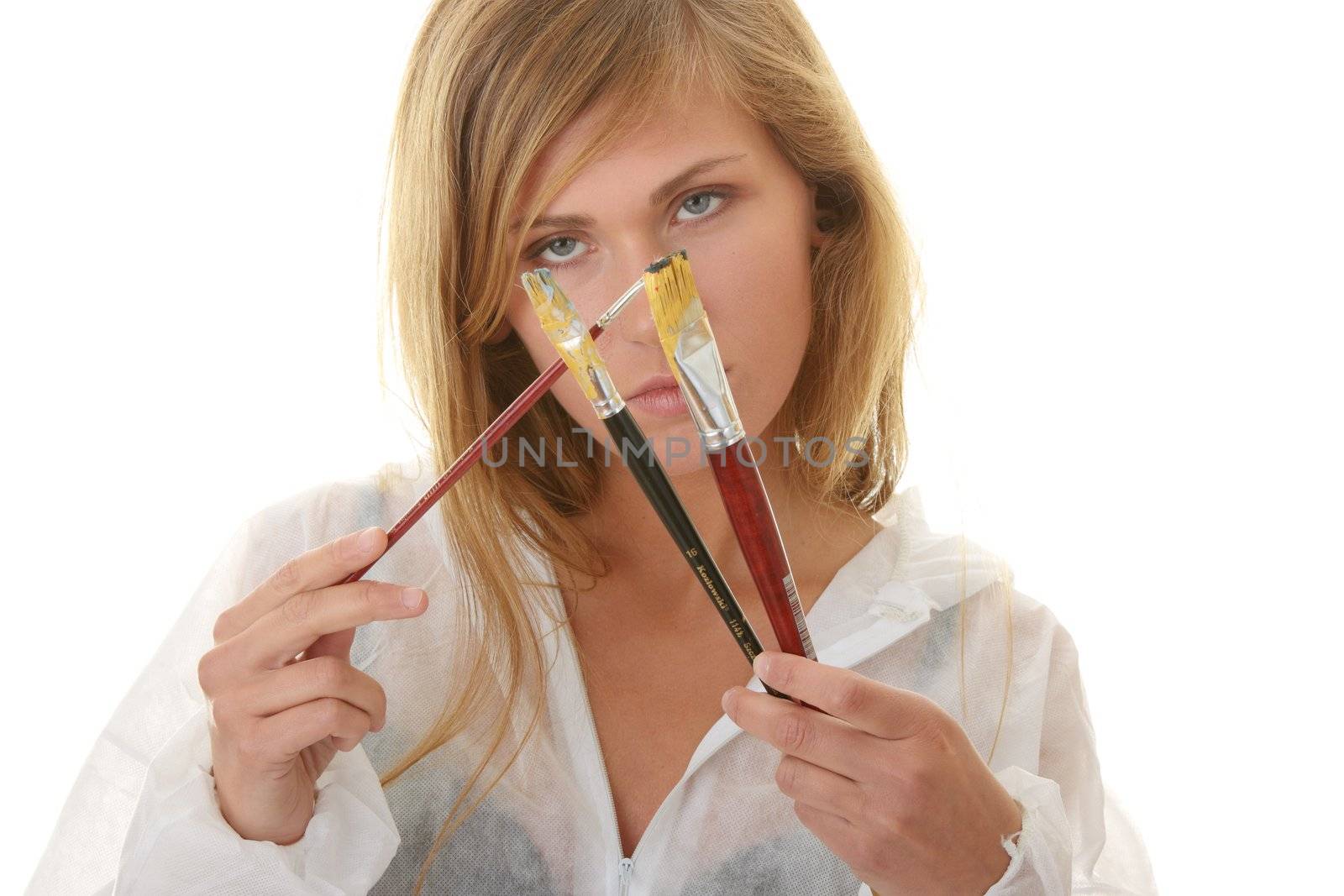 A female blond artist in white uniform with brushes - painting