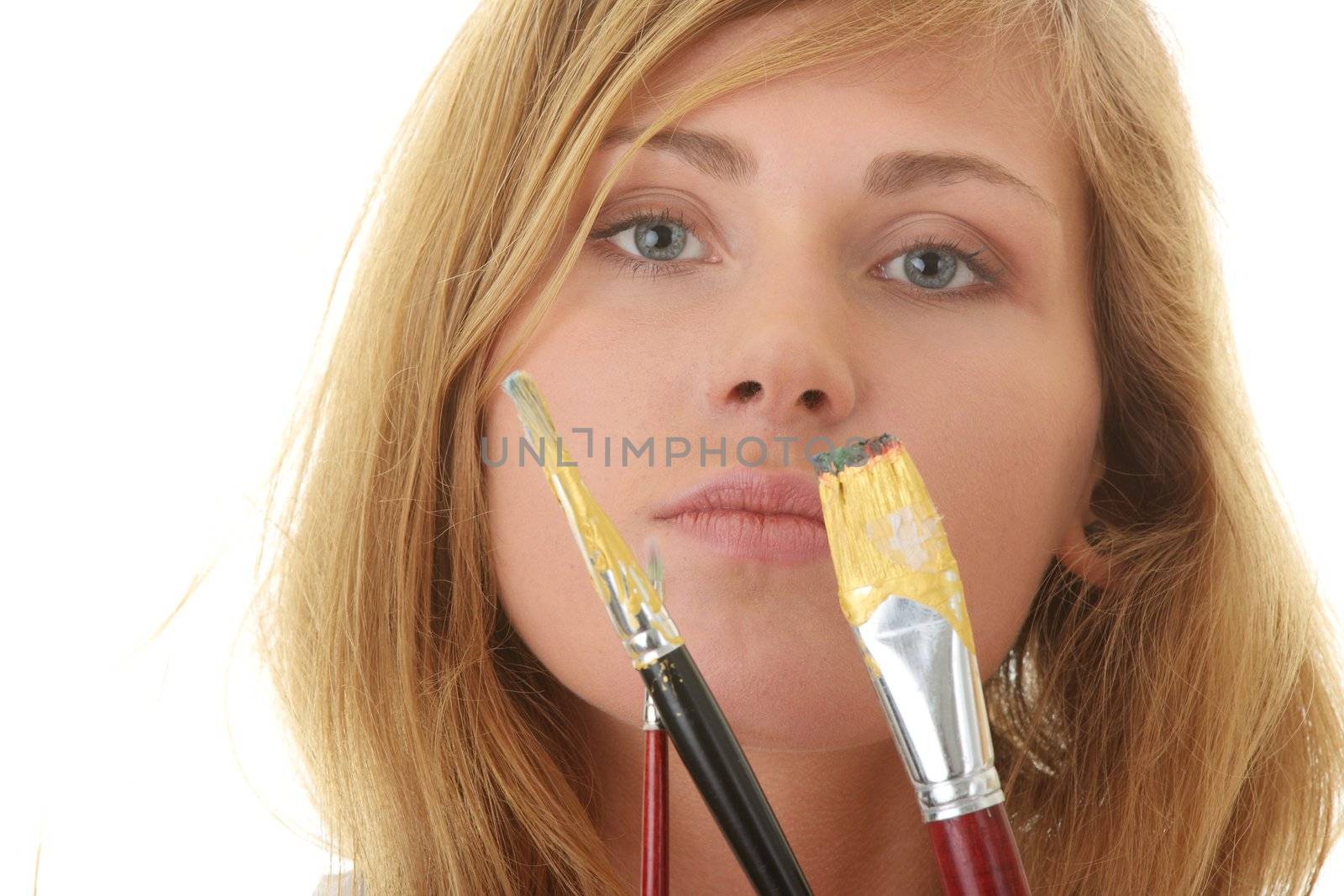 A female blond artist in white uniform with brushes - painting