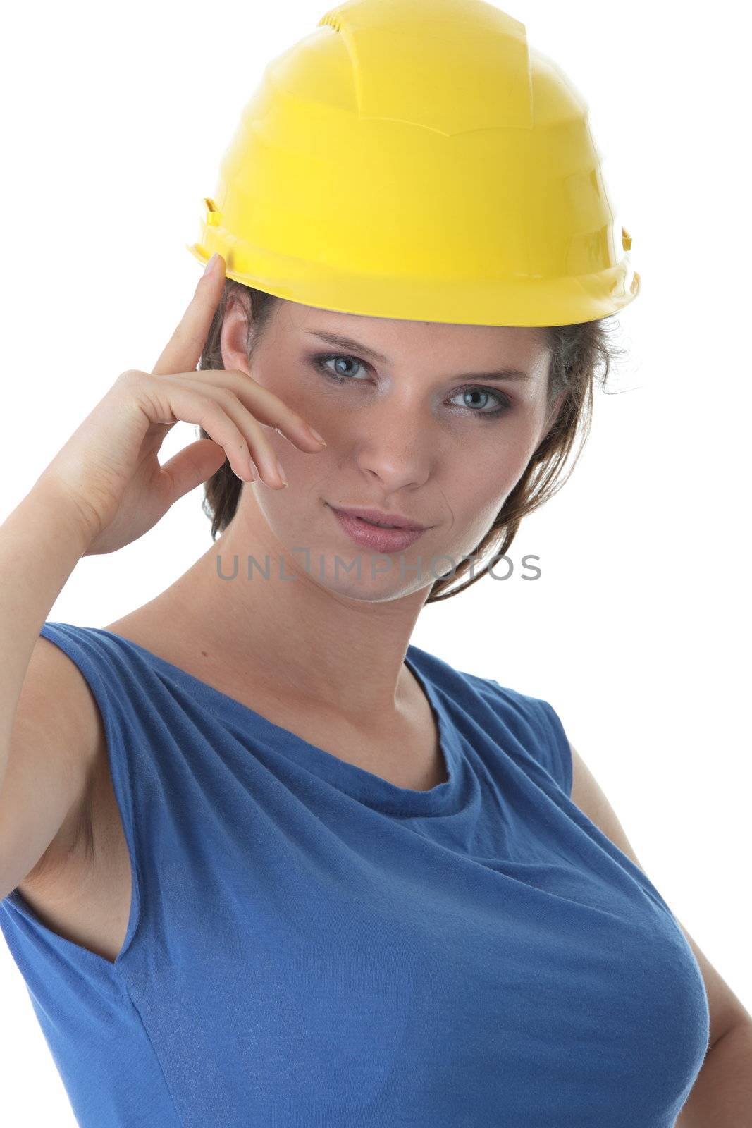 Young female architect or builder wearing a yellow hart hat on a construction site