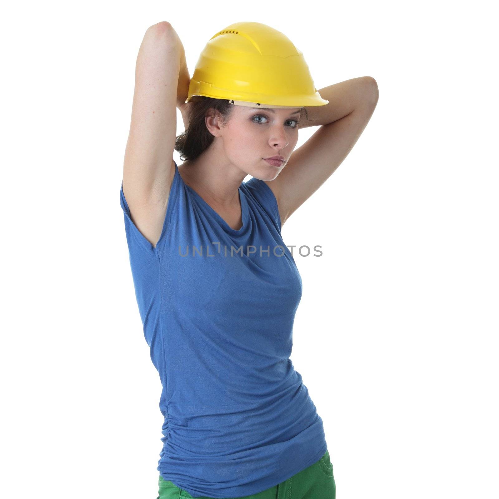 Young female architect or builder wearing a yellow hart hat on a construction site