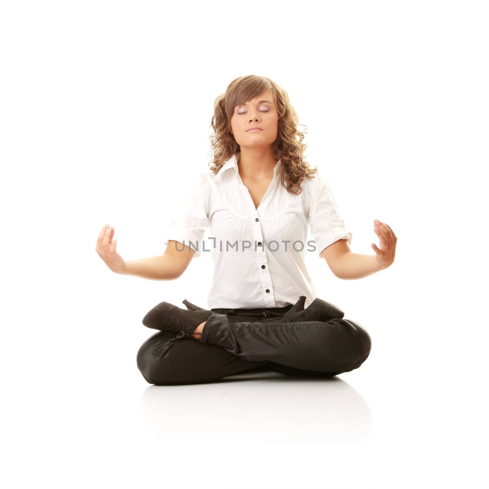Businesswomen meditating in lotus position by BDS