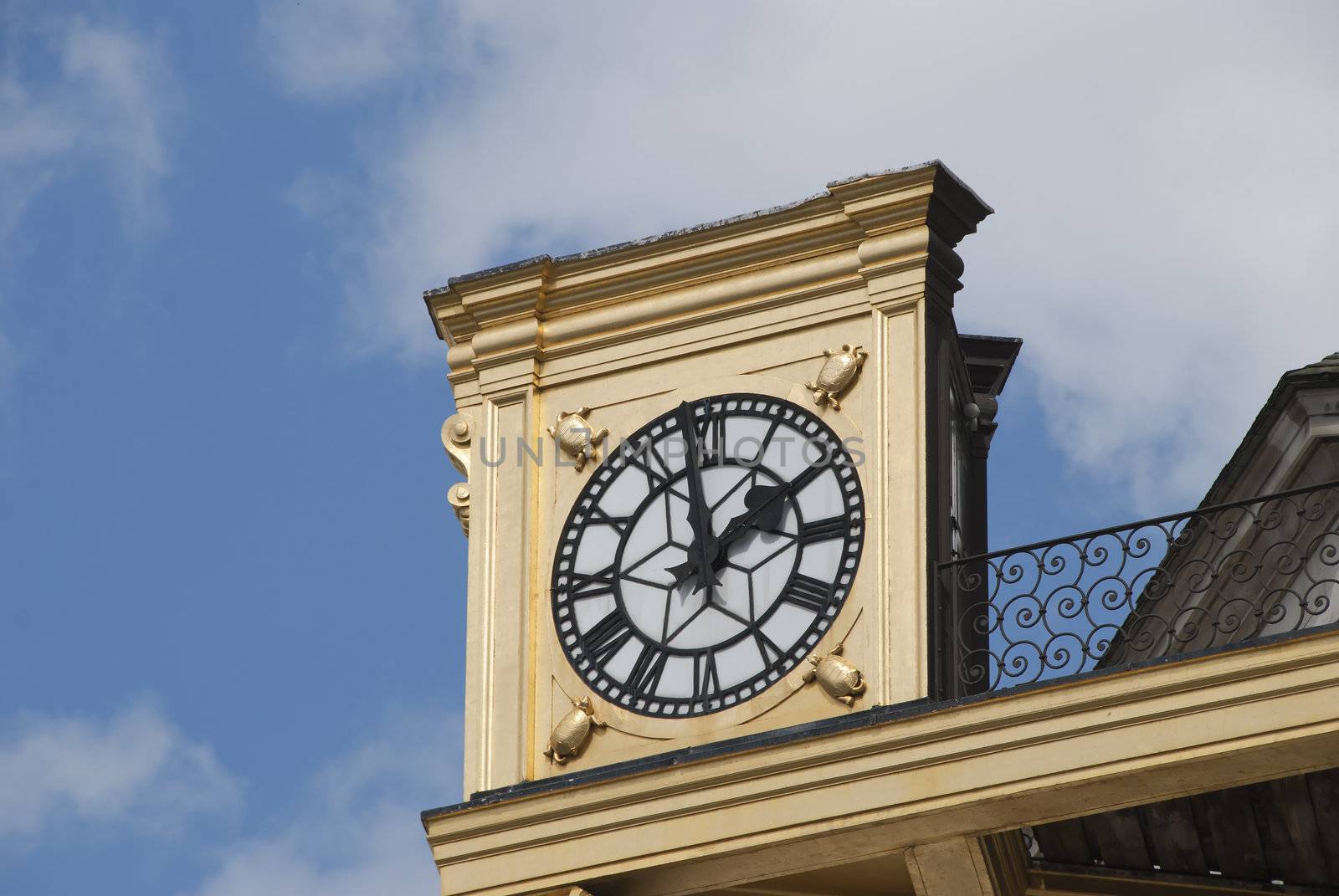 An Antique Gold Coloured Clock on a civic building in an English City