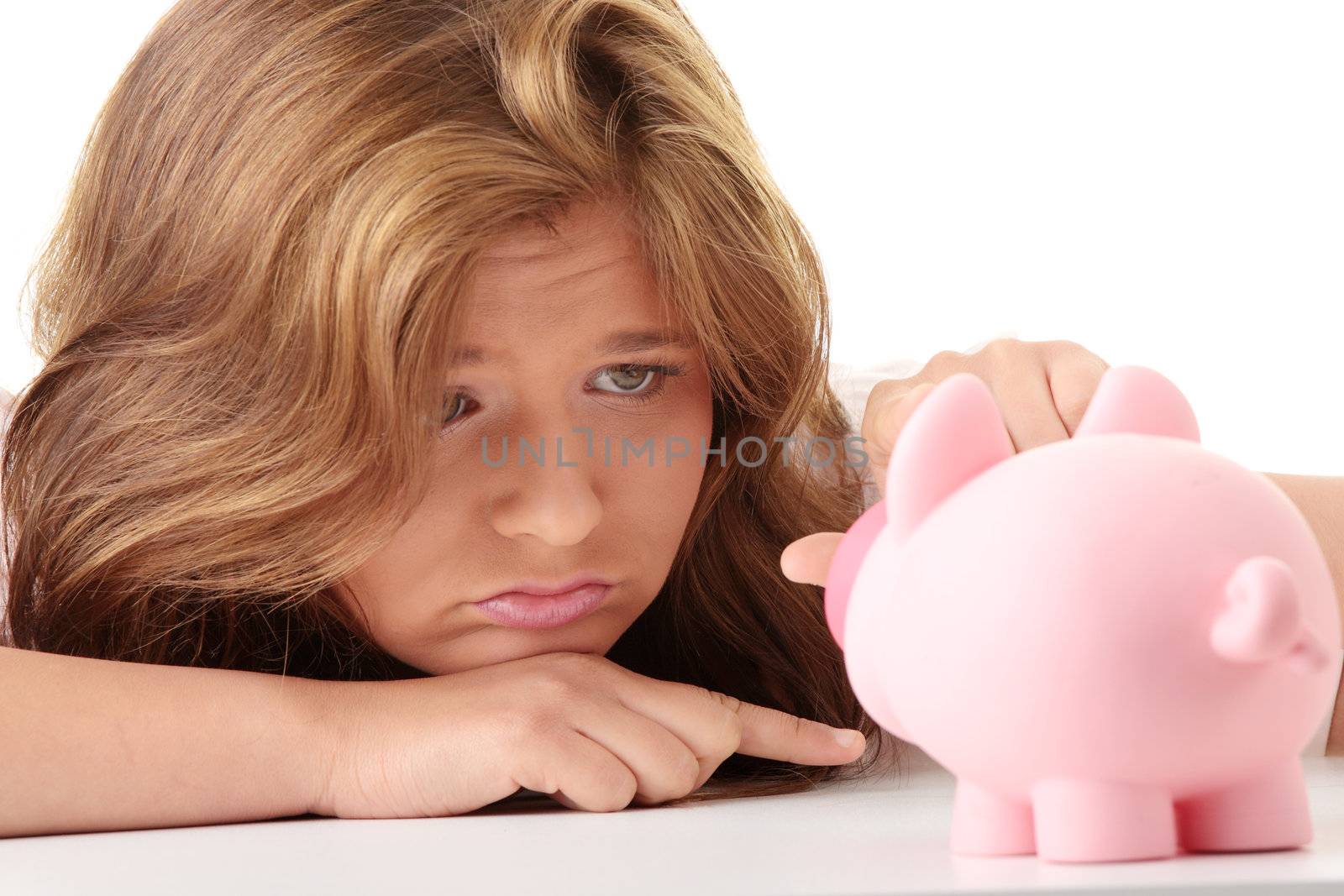 Young beautiful woman siting at the desk with piggy bank (money box), isolated on white background