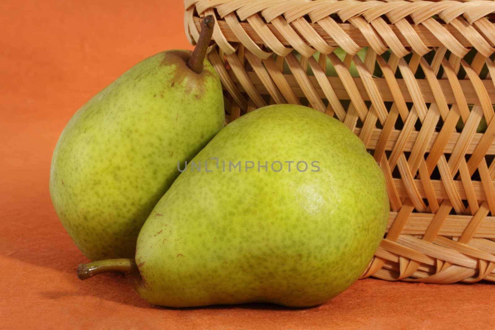 two bartlett pears near a wicker basket