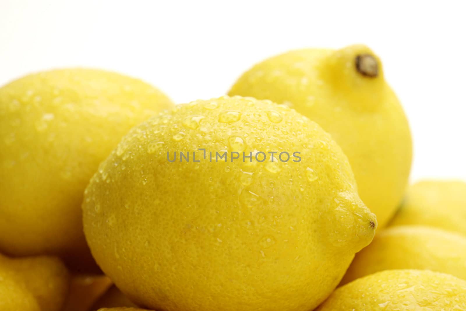 pile of fresh lemons with water drops