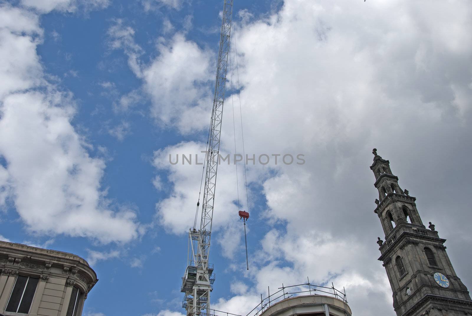 A Nineteenth Century Clocktower and a white crane against a blue sky