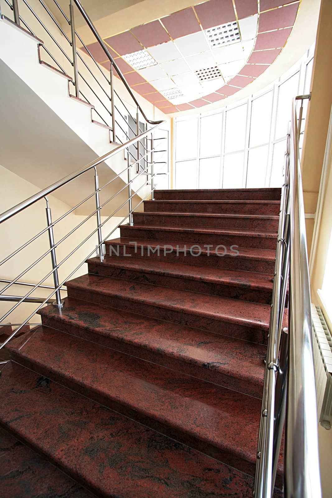 Marble staircase with a steel handrail in a modern building