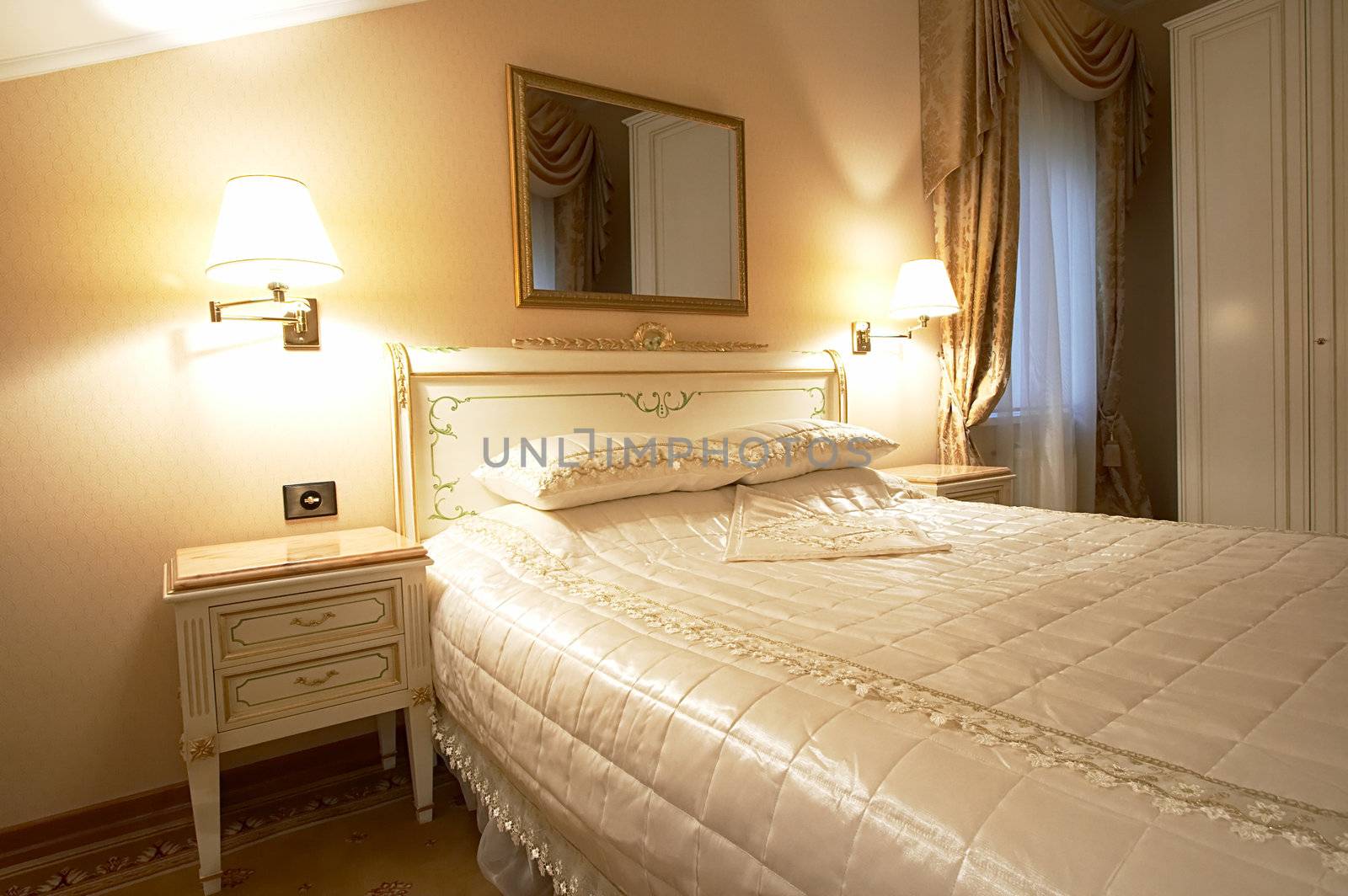 Wide bed and mirror in modern hotel