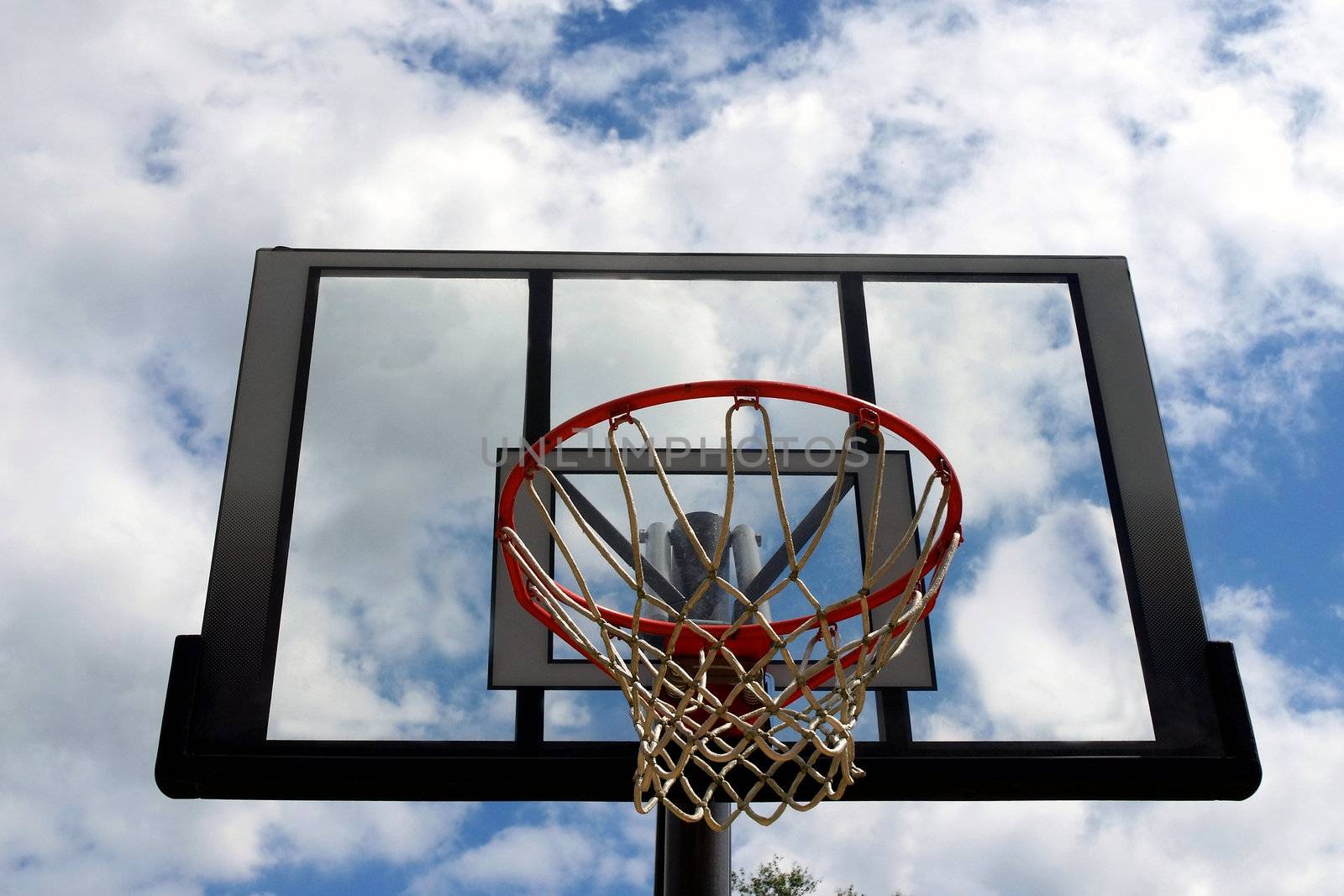 An outdoor basketball net with blue sky background