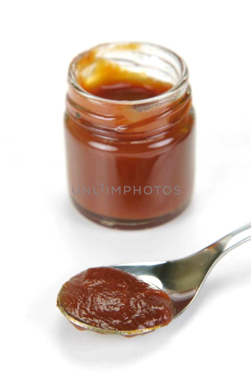 A small jar of ketchup isolated against a white background