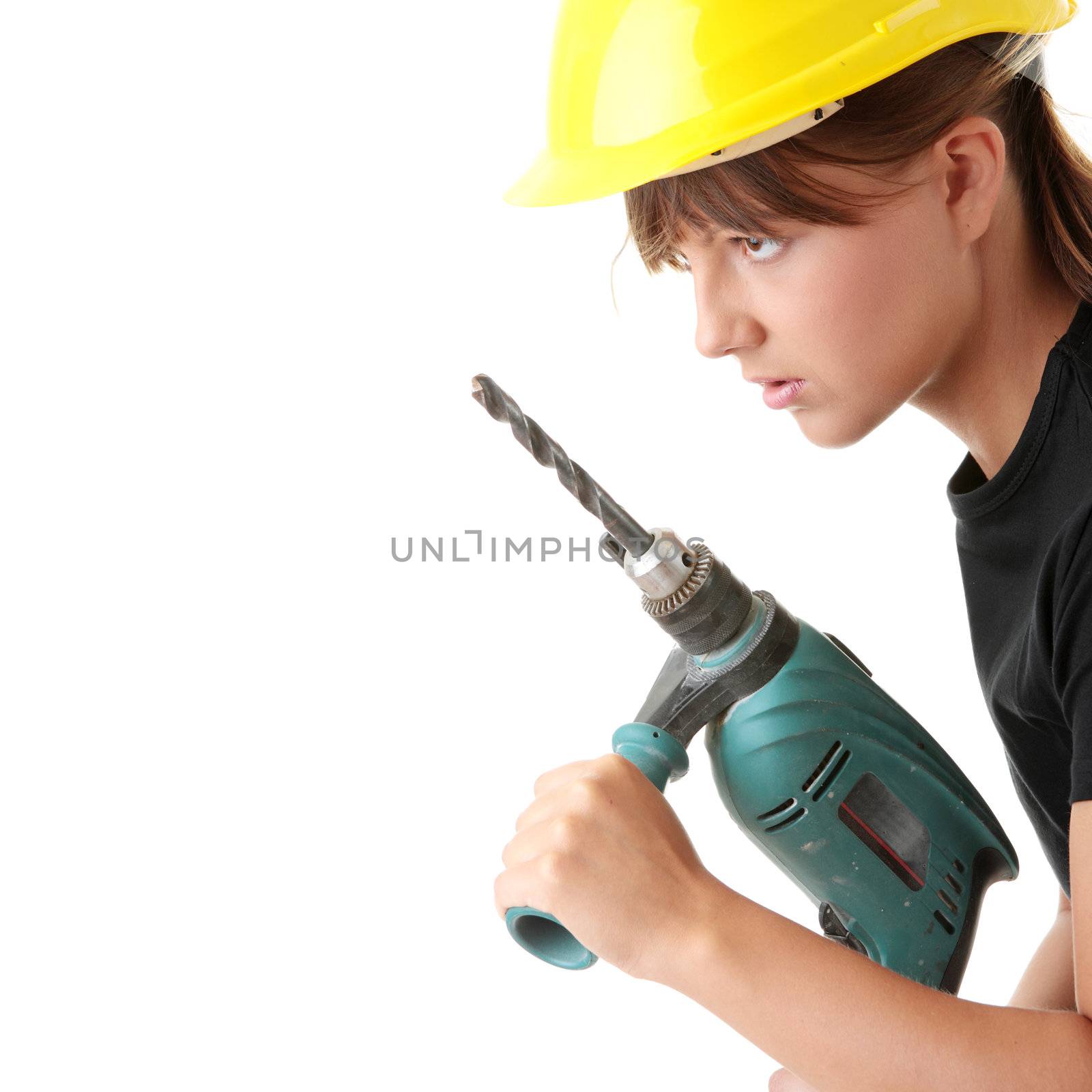 Young woman builder in yellow helmet holding driller