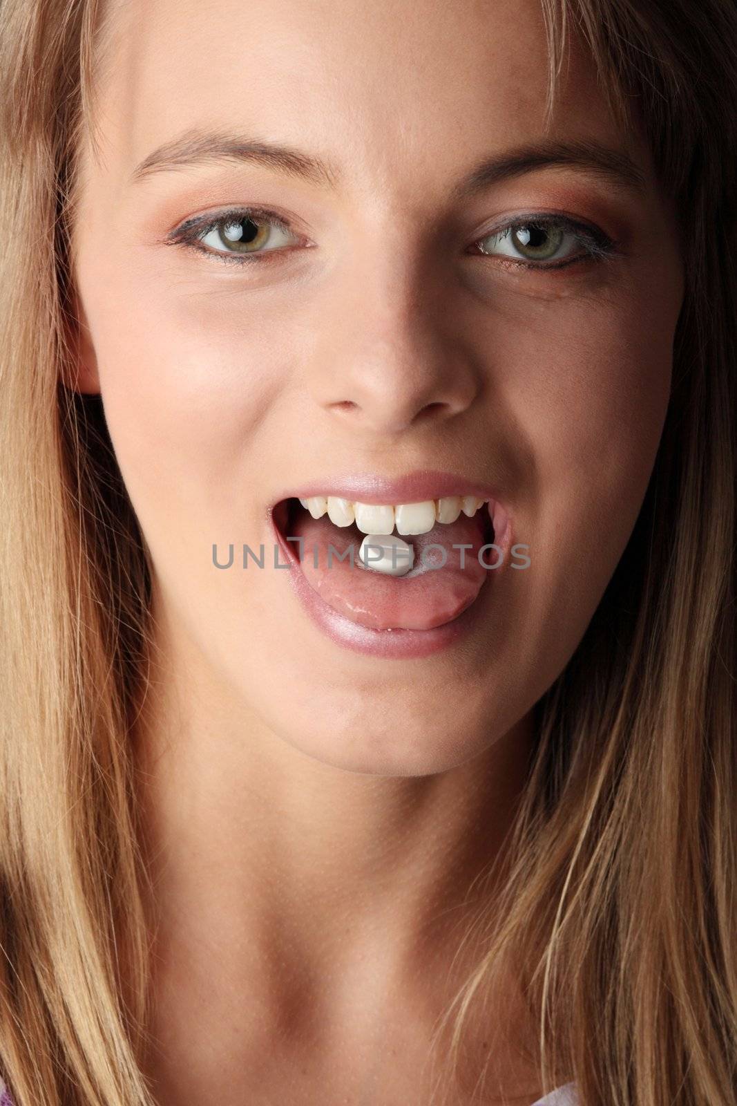 Young woman eating a pill