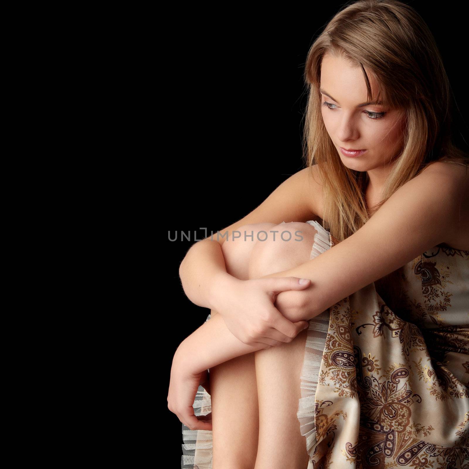 Young beautiful woman in gold dress portrait isolated on black background