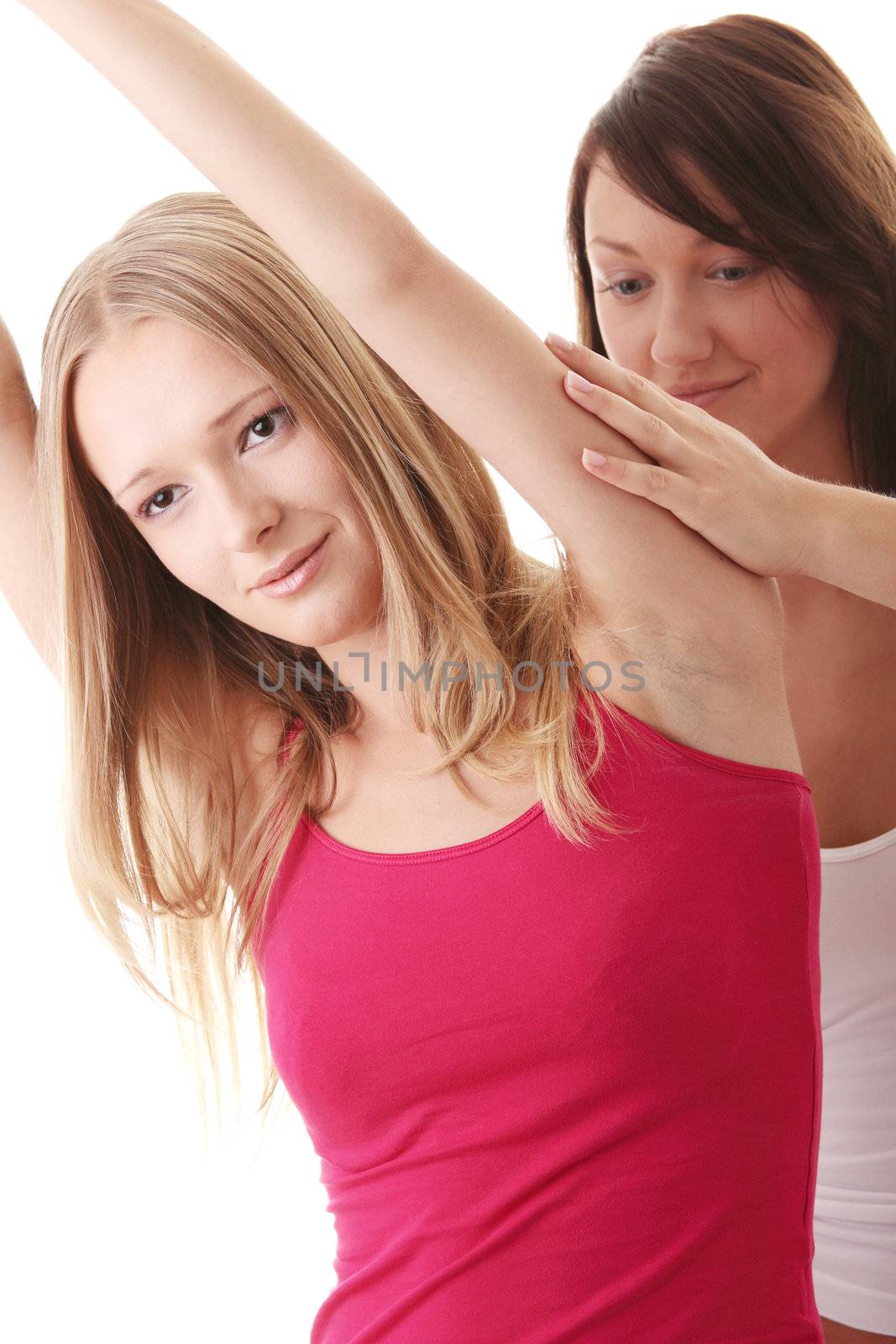 Two young fitness woman while exercising isolated on white